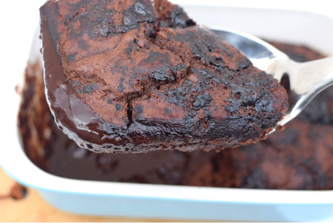 Spoonful of choc pudding with dish in the background